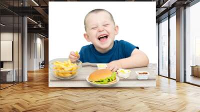 a little boy sits at a table where they fried, hamburger, sauces and laughs. The child is happy and is going to eat junk food. The idea is that you can't laugh at the table, you can choke. Wall mural