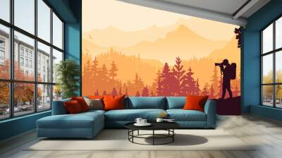 Photographer stands on hill take picture of landscape. Mountains and forest in background. Orange silhouette illustration. Banner.  Wall mural