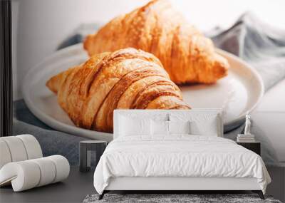 Plate with two fresh croissants on white wooden table. Wall mural