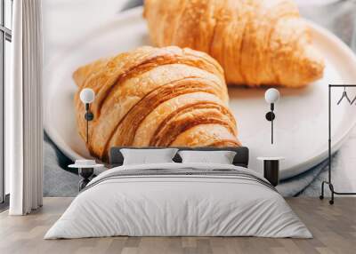 Plate with two fresh croissants on white wooden table. Wall mural