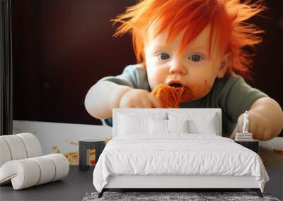 Red-haired baby boy eating spaghetti in the kitchen.  Wall mural