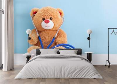 Teddy bear with stethoscope on blue background with space to copy; concept fun Pediatrics; children's medicine Wall mural