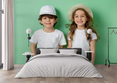 two young model kids boy and girl with blank white canvas t-shirts. pastel green wall background Wall mural