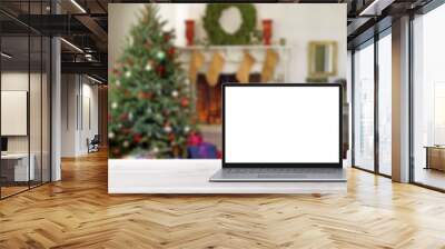 Blank display screen laptop computer on white wood table. Modern cozy comfortable home living room with Christmas decor. Home office desk workspace. Mock up copy space. Winter sales, online shopping Wall mural