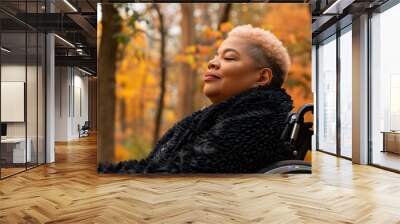 Woman in wheelchair enjoying tranquil autumn forest. Accessibility, inclusivity and mindfulness in nature. Wall mural