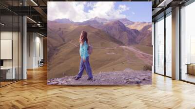 Woman is standing on the high mountain in Kazbegi, Georgia Wall mural