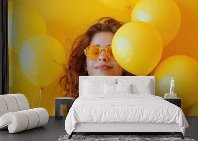 Yellow Day Celebration: Stylish Woman with Yellow Balloons on Yellow Background. Wall mural