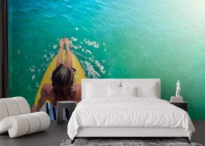 Young beautiful woman relaxing in the sea on a sup board.Top view. Copy space Wall mural