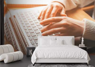 Young woman working in home on her laptop computer. Wall mural