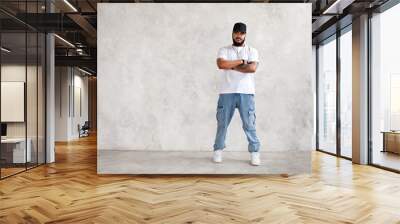 Full length portrait Hispanic man stands arms crossed, in casual wear jeans and white mockup T-shirt and baseball cap, cool guy looks at camera against gray wall Wall mural