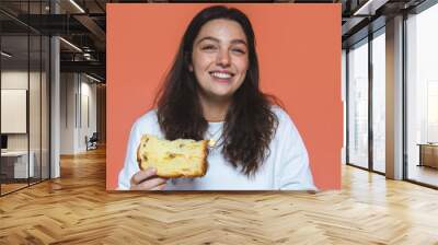 Young woman eating a slice of panettone Wall mural