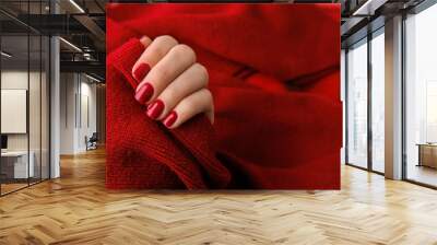 Woman manicured hands, stylish red nails, copy space. Red sweater Closeup. Winter or autumn style of nail design concept. Beauty treatment Wall mural