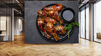 glazed teriyaki chicken legs on black plate Wall mural