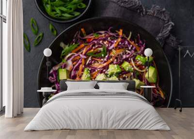 healthy rainbow cole slaw, red cabbage, avocado, carrot and bell pepper salad in black bowl Wall mural