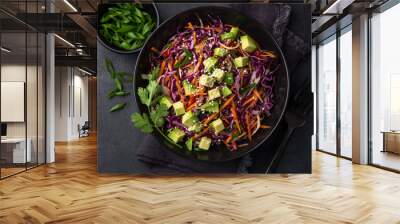 healthy rainbow cole slow, red cabbage, avocado, carrot and bell pepper salad in black bowl Wall mural