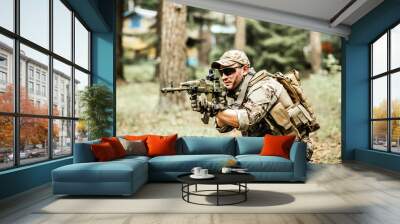 military. Armed man in a zone of armed conflict soldier in uniform targeting with assault rifle outdoors, airsoft Wall mural