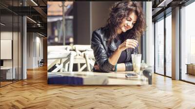 Brunette beautiful stylish caucasian woman in casual outfit on a walk on european city street sitting at the cafe waiting. copy space Wall mural