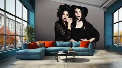 Gothic caucasian women in dark dresses on a grey neutral background. Contrast light. Sad, thoughtful emotions Wall mural