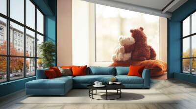 Two embracing teddy bear toys sitting on window-sill Wall mural