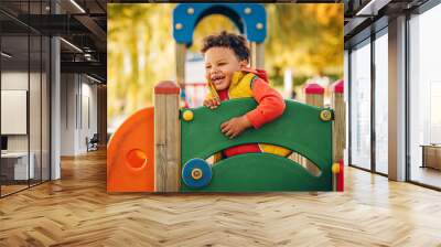 adorable little 1-2 year old toddler boy having fun on playground, child wearing orange hoody jacket Wall mural