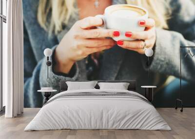 Cup of coffee in woman's hands with bright red manicure Wall mural