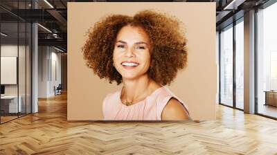 Fashion studio portrait of stylish middle age woman posing on beige background, smiling 50 - 55 year old lady with curly hair Wall mural