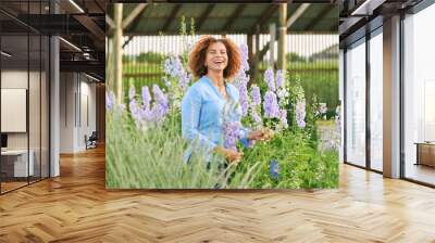 Outdoor portrait of beautiful 50 year old woman enjoying nice day in flower park or garden, happy and healthy lifestyle Wall mural