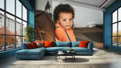 Portrait of adorable african kid boy resting on a couch Wall mural