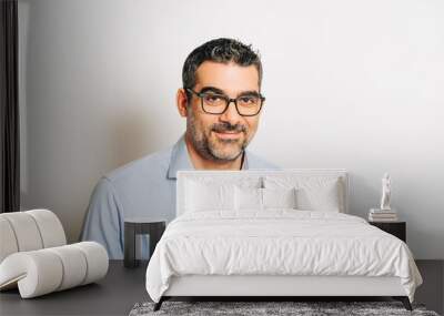 Studio portrait of handsome man wearing formal blue shirt and glasses, posing on white background Wall mural