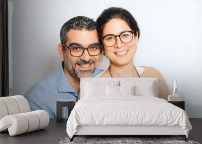 Studio portrait of happy couple wearing eyeglasses, posing together on white background Wall mural