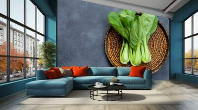 Bok choy fresh salad on wooden plate. Grey background. Top view. Copy space. Wall mural