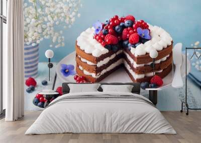 Chocolate cake with whipped cream and fresh berries. Blue wooden background. Close up. Wall mural