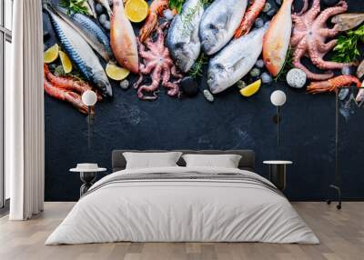 Fresh fish and seafood assortment on black slate background. Top view. Copy space. Wall mural