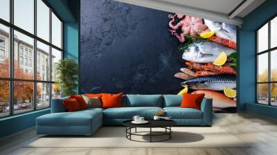 Fresh raw fish and seafood assortment on black slate background. Top view. Copy space. Wall mural