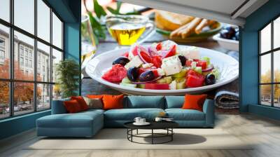 Greek salad. Fresh vegetables, feta cheese and black olives with white wine. Outdoor background. Wall mural