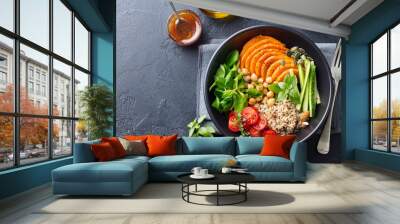 Healthy vegetarian salad. Roasted pumpkin, quinoa, tomatoes, green salad. Buddha bowl. Slate background. Top view. Wall mural