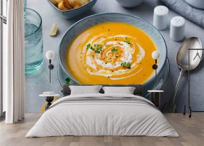 Pumpkin and carrot soup with cream on grey stone background. Close up. Wall mural