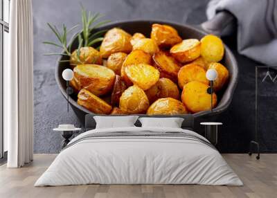 Roasted baby potatoes in iron skillet. Dark grey background. Close up. Wall mural