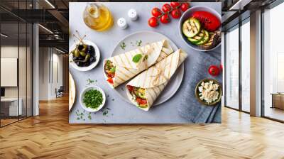 Wrap sandwich with grilled vegetables and feta cheese on a plate. Grey background. Top view. Wall mural