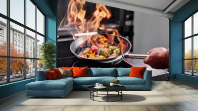 Close-up of professional chef in a commercial kitchen cooking flambe style Wall mural