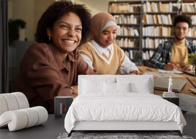 Group of students studying foreign language together at table in library Wall mural