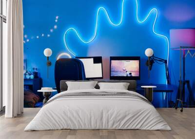 Horizontal image of place of streamer with computer monitors with video game and microphone in dark room decorated neon lights Wall mural