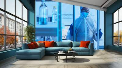 Unrecognizable male medical scientist in protective workwear opening doors and entering laboratory room, horizontal shot, copy space Wall mural