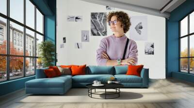 Young woman in eyeglasses standing with her arms crossed at gallery of modern art Wall mural