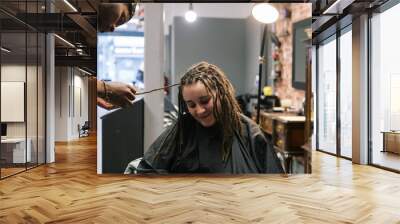 African master hairdresser  making dreadlocks for young woman in hair salon Wall mural