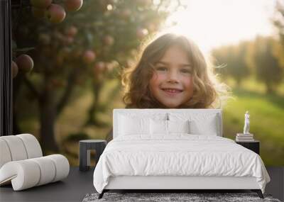 Portrait of a cute little girl in an apple orchard. Wall mural