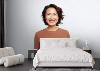 Portrait of a happy asian woman standing isolated over white background Wall mural