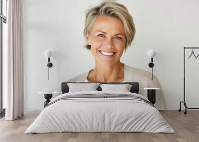 Portrait of a happy Polish woman in her 40s wearing a chic cardigan against a white background Wall mural