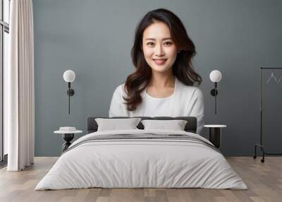 Portrait of a happy young businesswoman standing with arms crossed isolated over gray background Wall mural