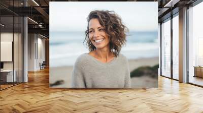 Portrait of a Israeli woman in her 40s wearing a cozy sweater against a beach background Wall mural